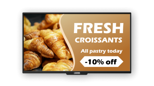 Close-up of golden, freshly baked croissants on a digital kiosk screen with a promotional offer of 10% off all pastries today displayed by LAKIOO.